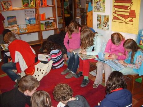 Des enfants assis dans la librairie Fundevogel lisent des livres. - Source de l'image: Eigenmaterial